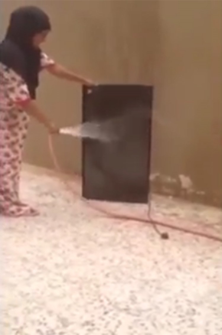 بالفيديو.. خادمة في الخليج "تتفانى" في عملها بغسل التلفزيون بخرطوم مياه
