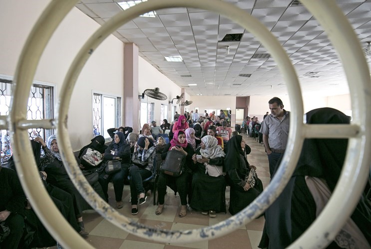 مجموعة من الفلسطينيين في جنوب قطاع غزة بانتظار الحصول على تصاريح السفر للعبور الى مصر عبر معبر رفح الحدودي افپ