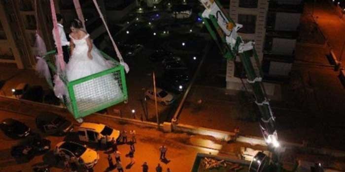 بالفيديو.. عروسان يصعدان لمنزل الزوجية بـ"الونش"!.. فما السبب؟