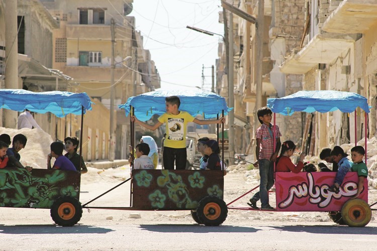 اطفال يركبون العربات احتفالا بعيد الاضحى في ادلب التي تسيطر عليها المعارضةرويترز