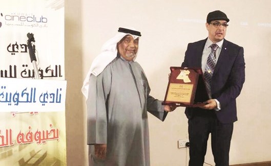 الزميل علاء البربري يسلم الفنان التشكيلي عادل المشعل درع التكريم﻿