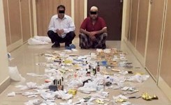الاسيويان وامامهما كمية من الادوية ﻿