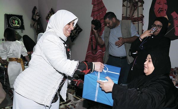 هند الصبيح تقدم هدية لاحدى المسنات 	(زين العابدين علام)