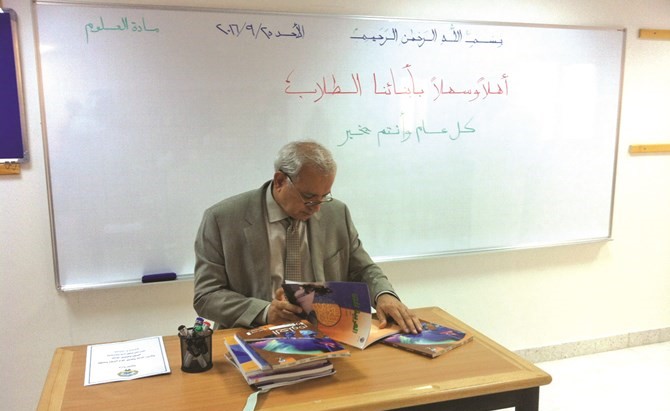 د بدر العيسى متصفحا كتب المناهج الدراسية باحد الفصول﻿