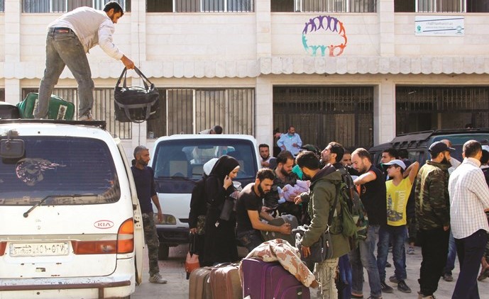 عشرات من المعارضة خلال ترحيلهم من بلدتي الهامة وقدسيا الى ادلب امس	رويترز﻿