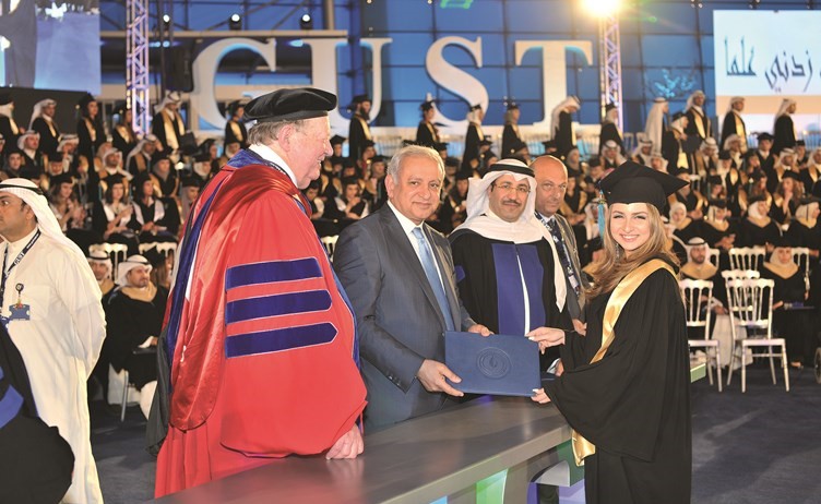 احدى الخريجات تتسلم تكريمها من دبدر العيسى ودصلاح الشرهان والبروفيسور دونالد بيتس﻿