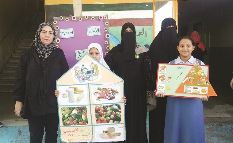 فاطمة العنزي ومنال عبدالهادي وايمان سالم يكرمون طالبتين أسهمتا بلوحات توعوية 