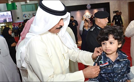 الشيخ محمد الخالد يقلد أحد الاطفال رتبة نقيب خلال تفقده المعرض التوعوي