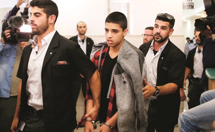 الطفل الفلسطيني احمد مناصرة والقيود بيديه خلال مغادرته المحكمة الاسرائيلية عقب الحكم بسجنه				( أ.ف.پ) ﻿