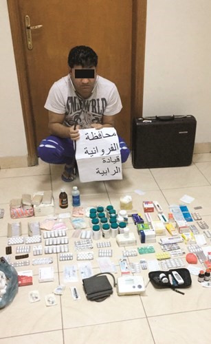 الوافد الهندي وأمامه بعض الأدوية والعلاجات لممارسة الطب﻿