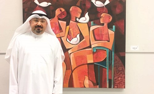 الفنان جابر أحمد مع إحدى لوحاته﻿