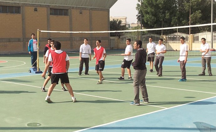 مجموعة من الطلبة يلعبون الكرة الطائرة ﻿