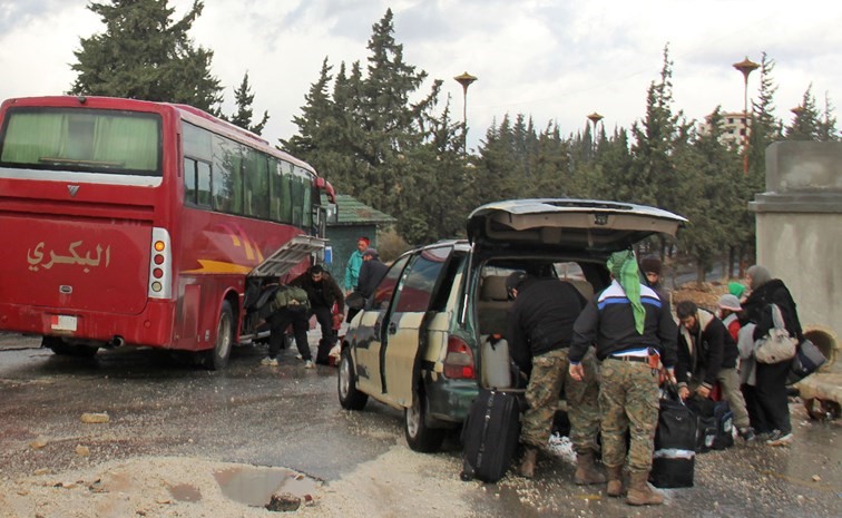 جانب من وصول مقاتلين من المعارضة السورية وعائلاتهم إلى ملجأ مؤقت في إدلب أمس 	(أ.ف.پ)﻿