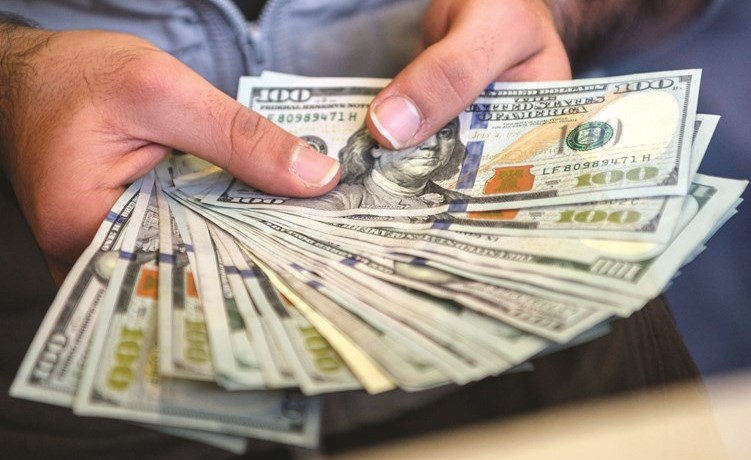 سعر صرف الدولار يواصل قفزاته مقابل الدينار في الصورة عامل في مكتب صرافة يعرض العملة الاميركية	(أ ف ب) ﻿