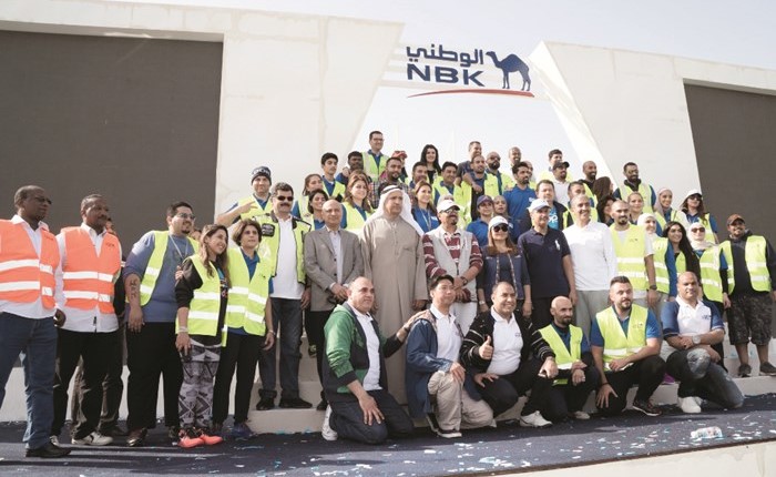 قيادات بنك الكويت الوطني والمتطوعون من البنك في صورة جماعية ﻿