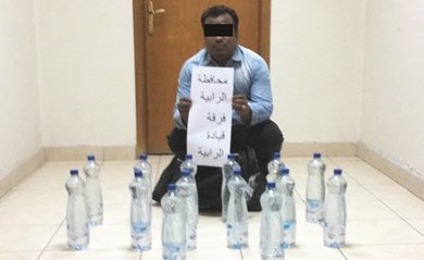 الهندي وأمامه قنينات الخمور ﻿