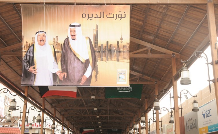 صورتا صاحب السمو الأمير وخادم الحرمين تزينان سوق المباركية ﻿