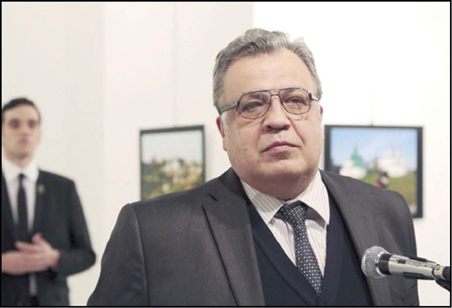  السفير متحدثا قبل لحظات من اغتياله وخلفه مطلق النار(ا.پ)