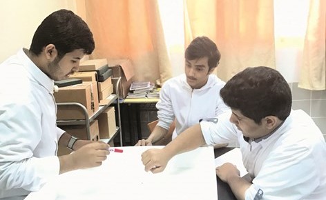 الطلاب إبراهيم الشنوف وفهد السعيدي وعمر الشمري خلال التجهيز للمشروع﻿