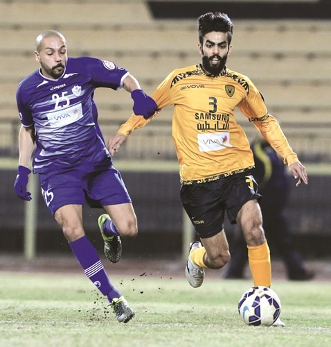 لاعب الأصفر أحمد الظفيري في سباق على الكرة مع لاعب الشباب عمر بوحمد	 (الأزرق. كوم)﻿