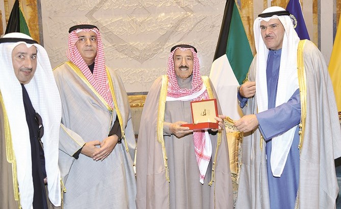 صاحب السمو يتسلم مسكوكة تذكارية بمناسبة اختيار الكويت عاصمة للثقافة الإسلامية من الشيخ سلمان الحمود ويبدو م. علي اليوحة ومحمد العسعوسي ﻿