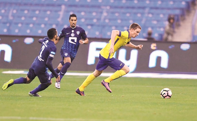 لاعب النصر مارين توماسوف يمر من مدافعي الهلال ﻿