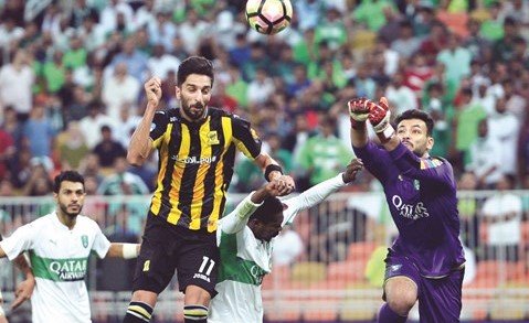 لاعب الاتحاد فهد الانصاري محاطا بين مدافعي وحارس الاهلي ﻿