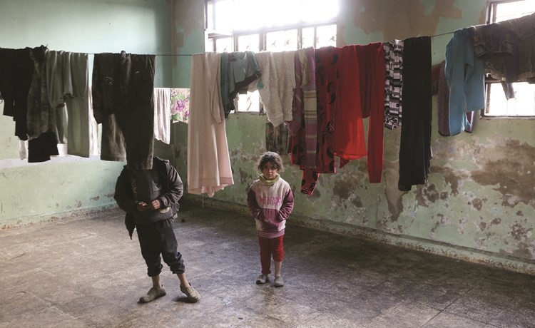 طفلان سوريان وحبل غسيل لعائلة فرت من داعش في الباب ولجأت الى مدرسة مهدمة في ريف حلب	(رويترز) ﻿