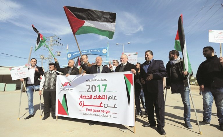 فلسطينيون يرفعون لافتات تطالب برفع الحصار عن غزة خلال تظاهرة في القطاع امس الاول	 (رويترز) ﻿
