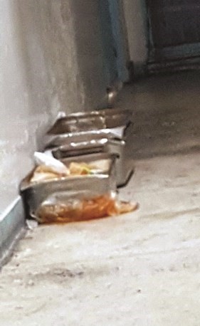 أواني الطعام مقابل الزنازين في أجواء بيئية غير نظيفة﻿