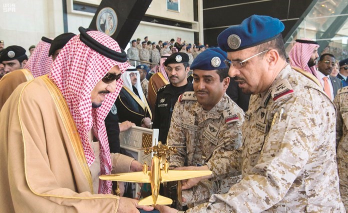 خادم الحرمين الشريفين الملك سلمان بن عبدالعزيز يتسلم هدية تذكارية من قائد كلية الملك فيصل الجوية امس	(واس) ﻿