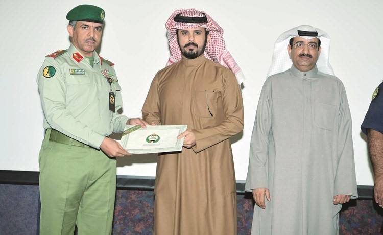 اللواء ركن فالح شجاع العتيبي وتركي العتيبي خلال تسليم شهادة التخرج لأحد الخريجين﻿