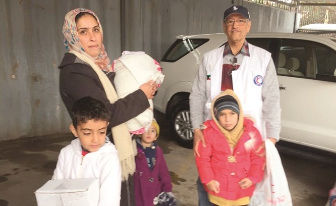نائب رئيس مجلس إدارة الجمعية أنور الحساوي مع إحدى العوائل السورية اللاجئة﻿