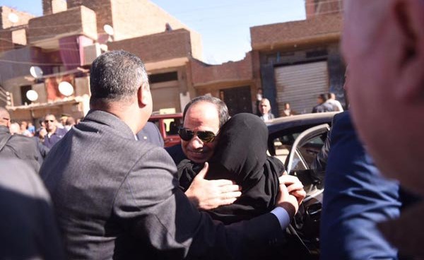 سيدة تحتضن الرئيس خلال جولته