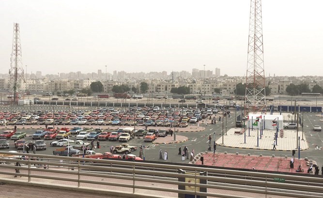 جمع من المشاركين والسيارات في مواقف ستاد جابر الدولي ﻿