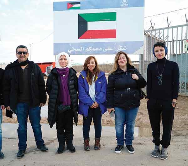  ايمان الروضان ود.حنان حمدان ووليد الخشتي وهيا المانع والزميلة اروى الوقيان امام لافتة شكر للكويت عند مدخل المخيم