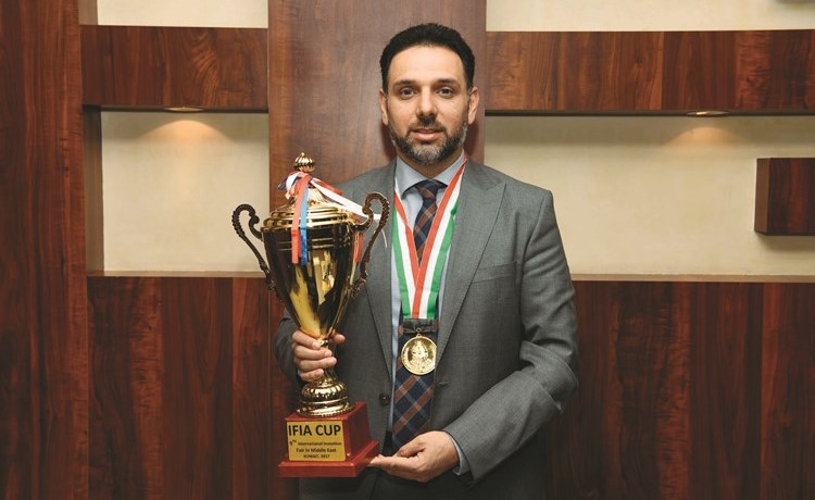 د. عبدالمحسن الصحاف حاملا كأس «إيفا» ومرتديا الميدالية الذهبية