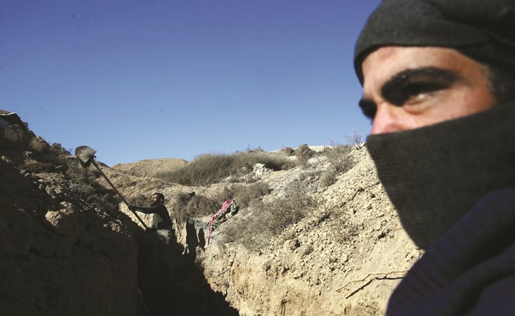 مقاتلونمعارضون ينتمون الى جيش الاسلام خلال حفر خندق في تل فرزات في الغوطة الشرقية أمس	(رويترز) ﻿
