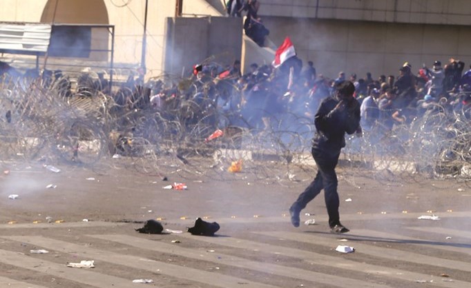 متظاهرون يهربون من الغاز المسيل للدموع الذي استخدمته الشرطة لتفريقهم	(ا.ب) ﻿