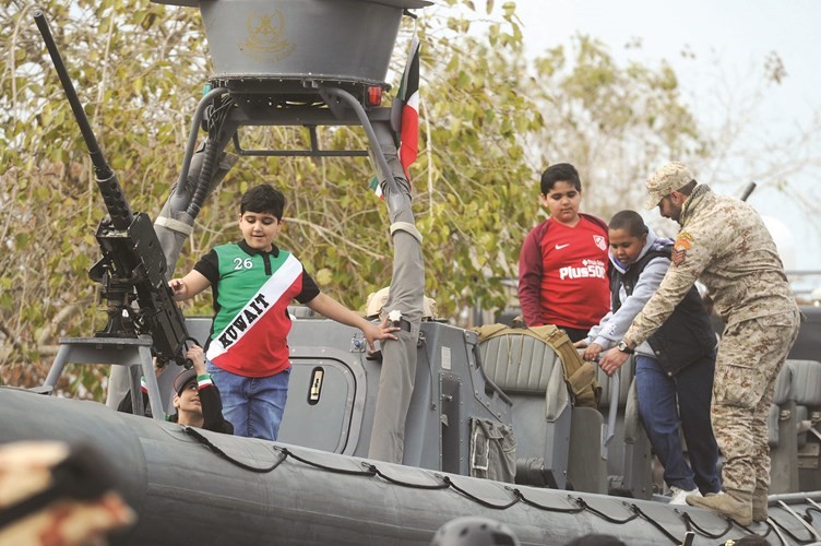 اطفال مشاركون في الاحتفالات على آلية عسكرية﻿