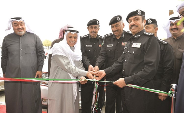مبارك ناصر الساير واللواء أديب السويدان لحظة قص شريط افتتاح مركز الساير لتسليم اللوحات﻿