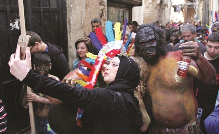 لبنانية تلتقط سيلفي مع متنكرين في مهرجان الزومبي عشية بدء الصوم عند الطوائف المسيحية في طرابلس	 (رويترز) ﻿