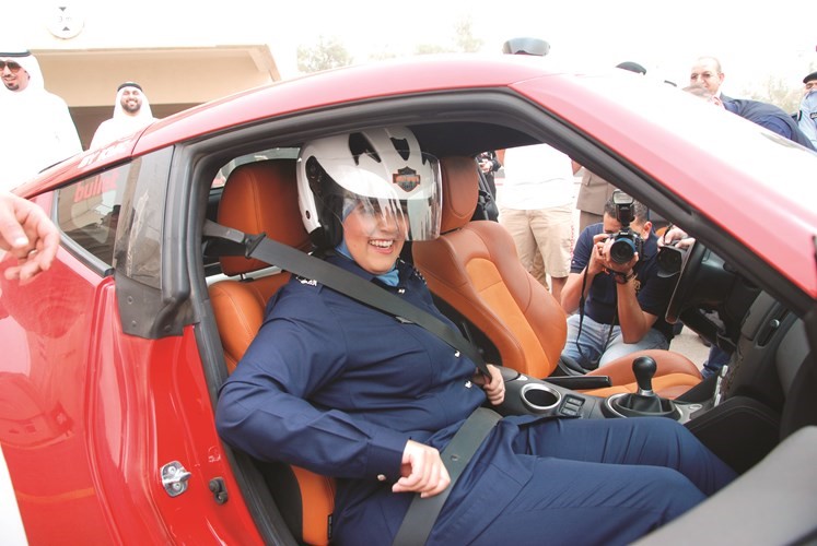 ضابطة خليجية مشاركة في الاسبوع المروري تجرب قيادة احدى مركبات السباق﻿