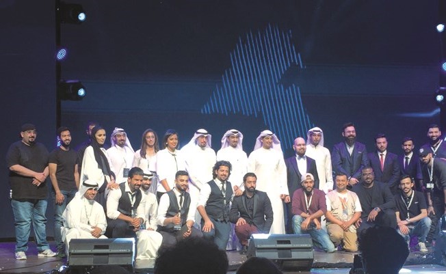 عبدالرحمن المطيري متوسطا مجموعة من المشاركين خلال الاحتفال﻿