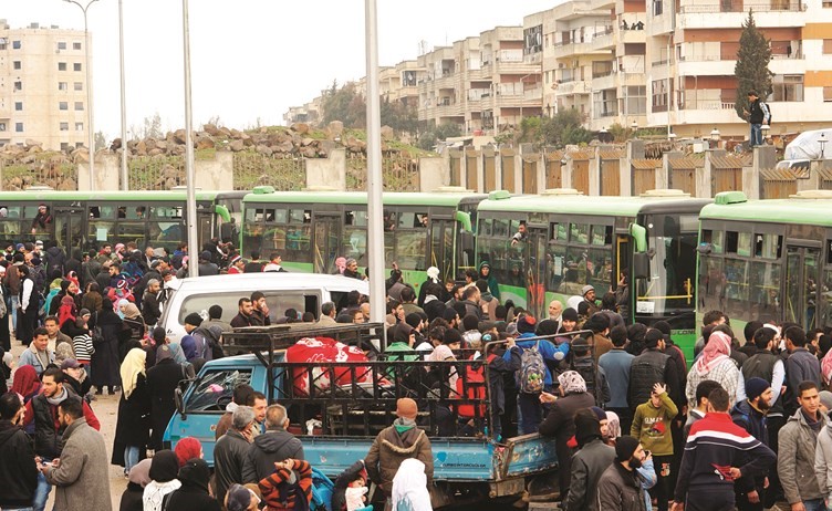 مدنيون من اهالي حمص يودعون ذويهم الذين خرجوا من حي الوعر ضمن اتفاق إخلاء الحي من المعارضة	(أ.ف.پ﻿)