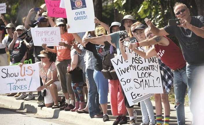 مناهضون لترامب يرفعون لافتات تندد بسياساته خلال تظاهرة في فلوريدا امس الاول	(ا.ف.ب)﻿