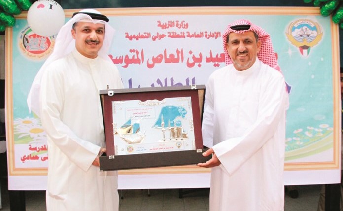  عبدالرحمن القديري يتسلم درعا تكريمية من مدير المدرسة سالم حمادي ﻿
