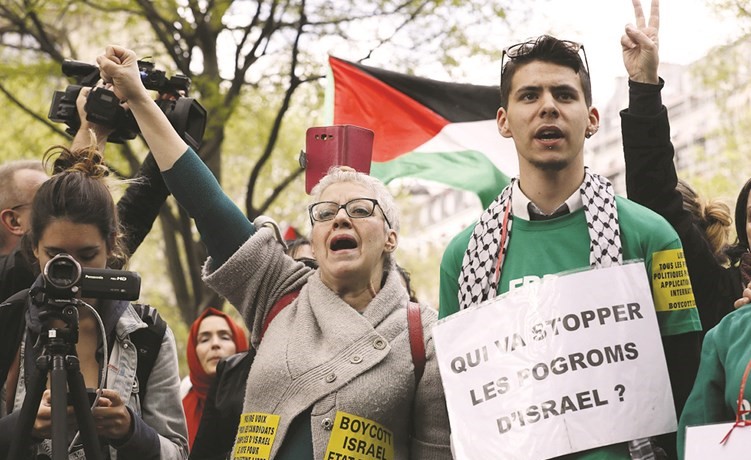 فرنسيون يرفعون لافتات تندد بالاستيطان الاسرائيلي في الاراضي الفلسطينيةخلال تظاهرة في باريس امس(أ.ف.پ)﻿