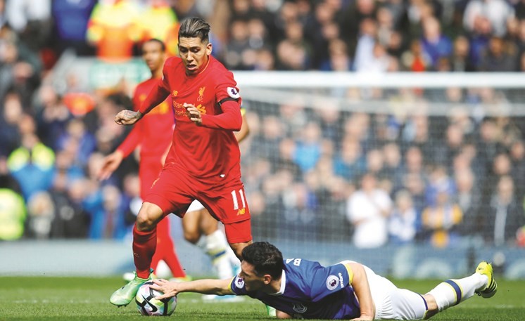 لاعب إيفرتون غاريث باري يمسك الكرة بيده ليمنع﻿﻿ مهاجم ليفربول روبرتو فيرمينو من التقدم (رويترز)﻿