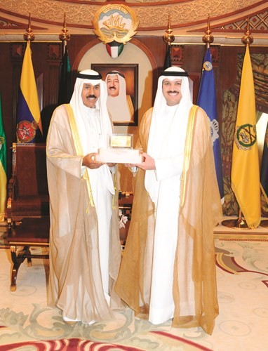 سمو ولي العهد الشيخ نواف الاحمد يتسلم الدينار الذهبي من د.محمد الهاشل ﻿